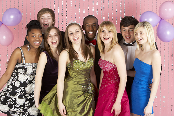 Teens dressed up and posing at prom party