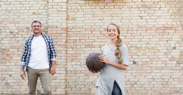 Daughter playing basketball with her dad