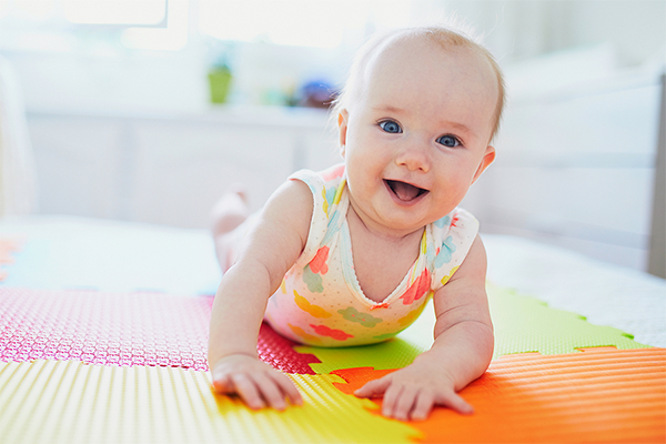 Baby smiling on colorful mat
