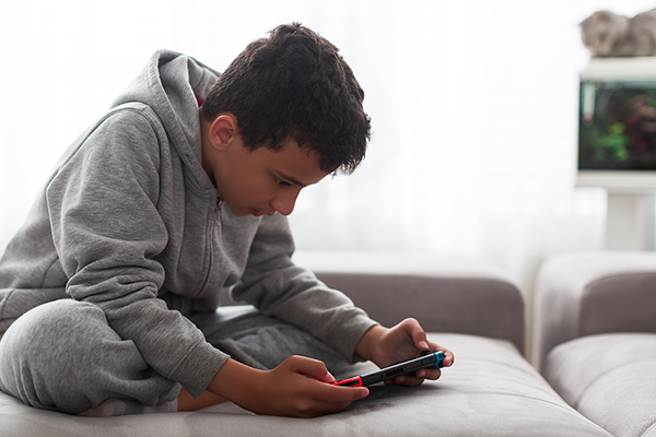 Young boy playing video game at home.