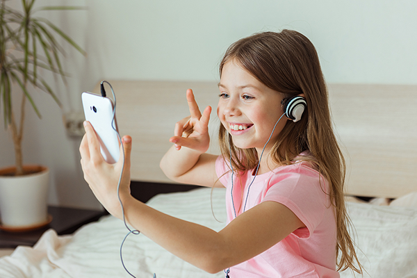 Child smiling talking to friend on video call